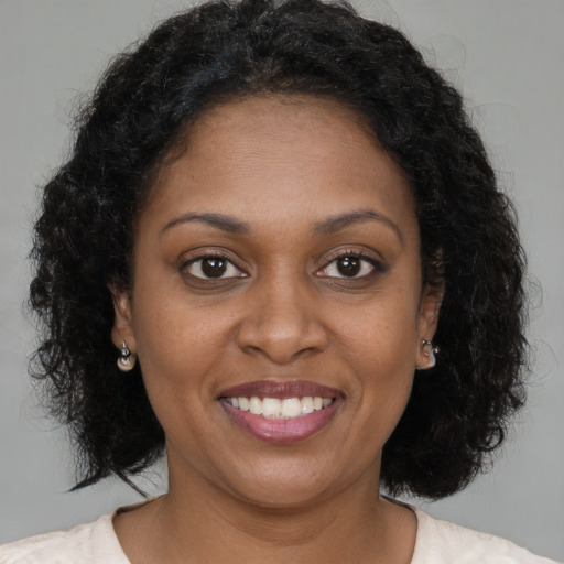 Joyful black young-adult female with medium  brown hair and brown eyes