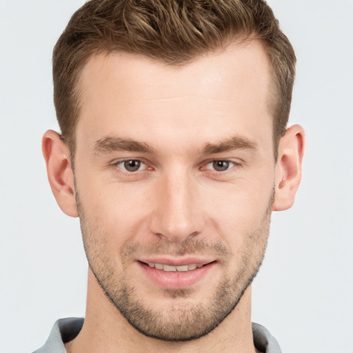 Joyful white young-adult male with short  brown hair and grey eyes