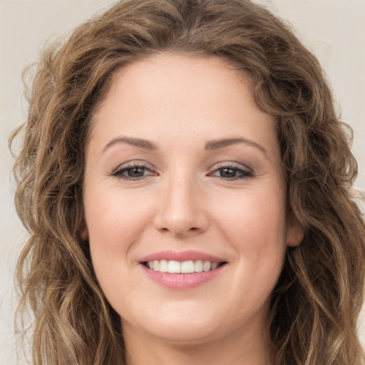 Joyful white young-adult female with long  brown hair and green eyes