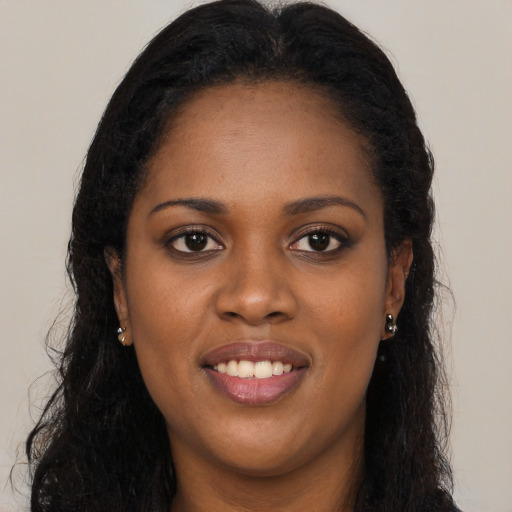 Joyful black young-adult female with long  brown hair and brown eyes