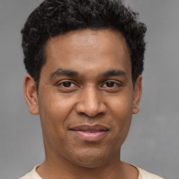 Joyful latino young-adult male with short  brown hair and brown eyes