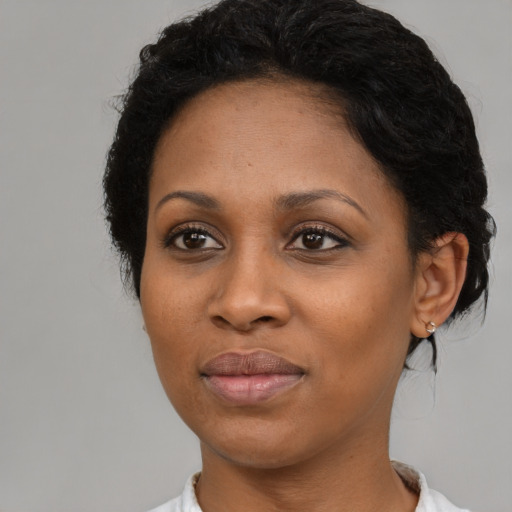 Joyful black adult female with short  black hair and brown eyes