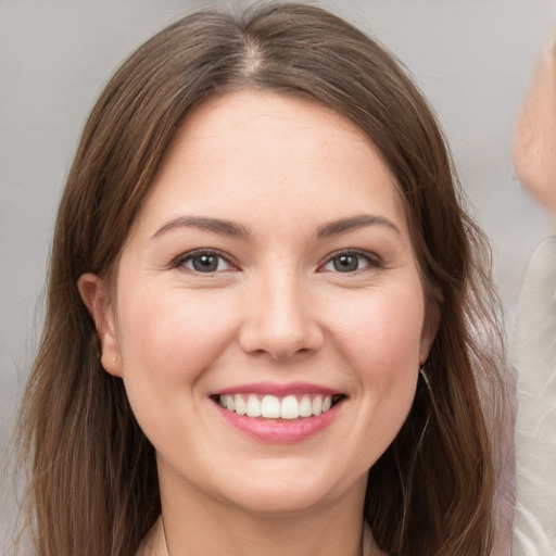 Joyful white young-adult female with long  brown hair and brown eyes