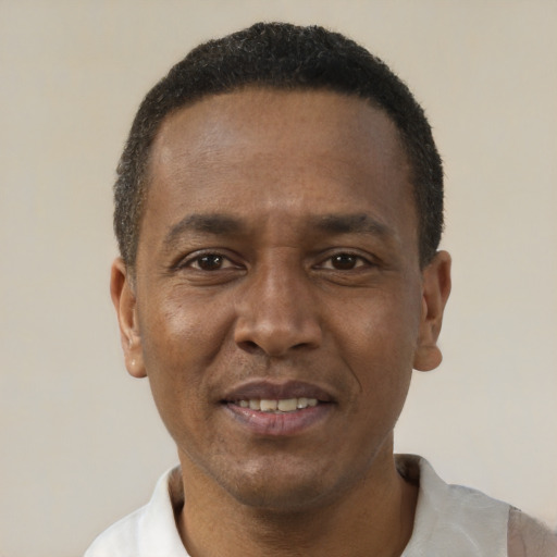 Joyful black adult male with short  black hair and brown eyes