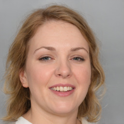 Joyful white young-adult female with medium  brown hair and blue eyes