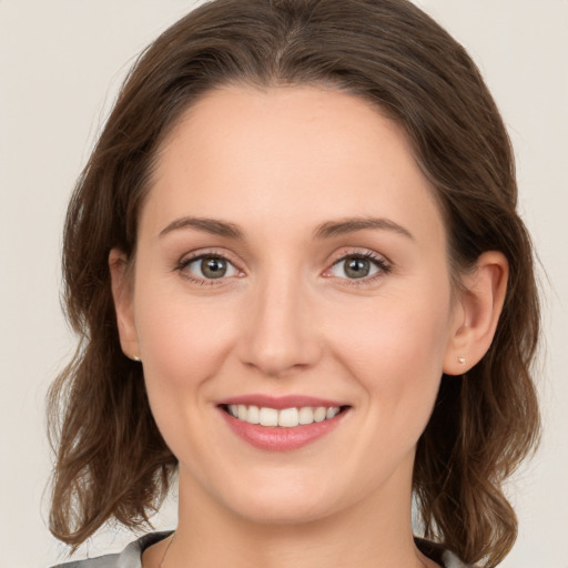 Joyful white young-adult female with medium  brown hair and green eyes