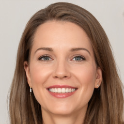 Joyful white young-adult female with long  brown hair and grey eyes