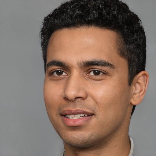 Joyful latino young-adult male with short  black hair and brown eyes