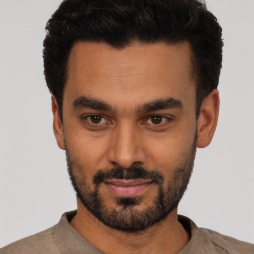 Joyful latino young-adult male with short  black hair and brown eyes