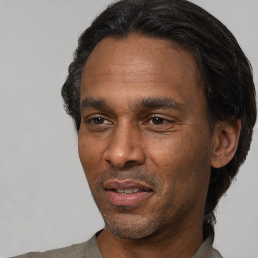Joyful black adult male with short  black hair and brown eyes