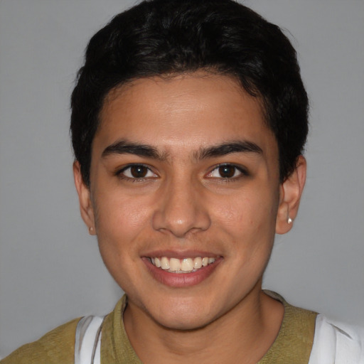 Joyful latino young-adult male with short  brown hair and brown eyes