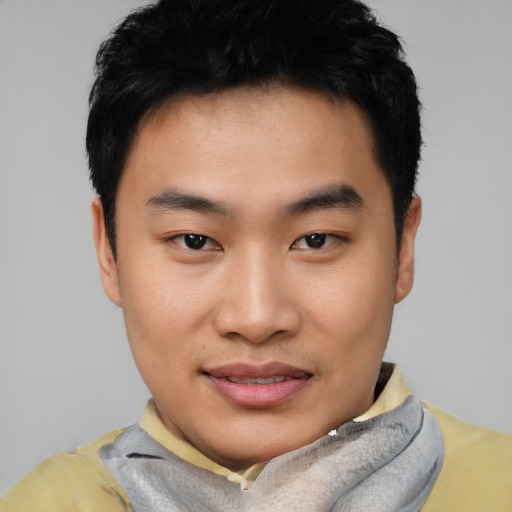 Joyful asian young-adult male with short  black hair and brown eyes
