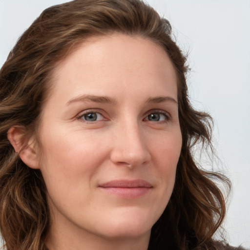 Joyful white young-adult female with long  brown hair and blue eyes