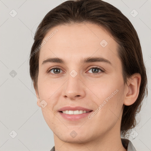 Joyful white young-adult female with medium  brown hair and grey eyes