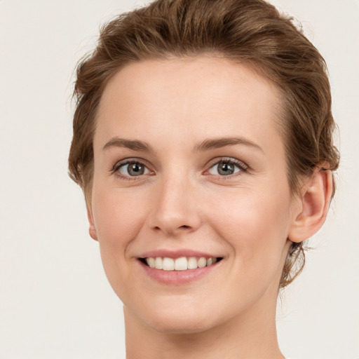 Joyful white young-adult female with short  brown hair and green eyes