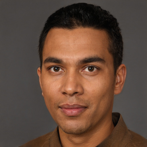 Joyful latino young-adult male with short  black hair and brown eyes