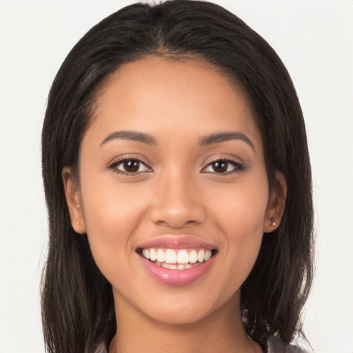 Joyful latino young-adult female with long  brown hair and brown eyes