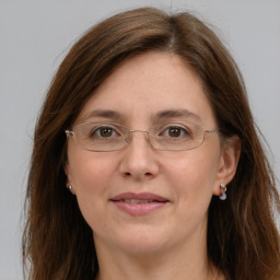 Joyful white adult female with long  brown hair and grey eyes