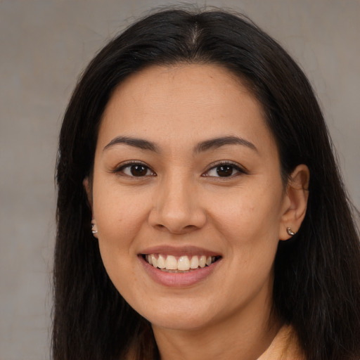 Joyful latino young-adult female with long  brown hair and brown eyes