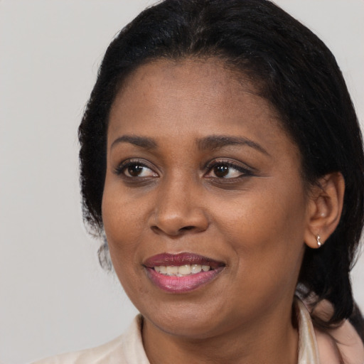 Joyful black adult female with long  black hair and brown eyes