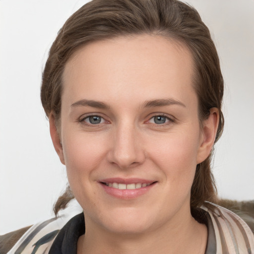 Joyful white young-adult female with medium  brown hair and grey eyes