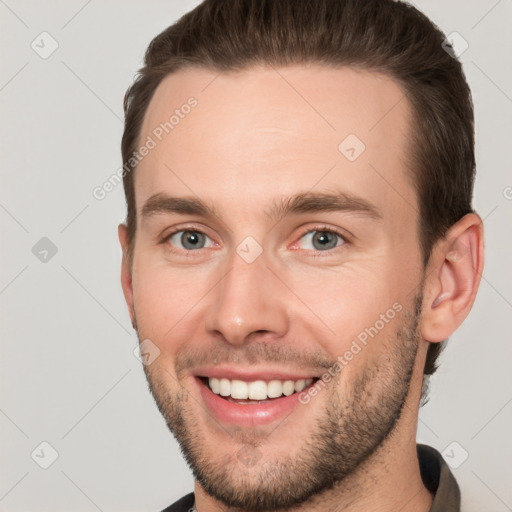 Joyful white young-adult male with short  brown hair and brown eyes