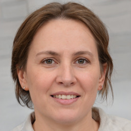 Joyful white adult female with medium  brown hair and grey eyes