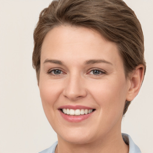 Joyful white young-adult female with short  brown hair and grey eyes