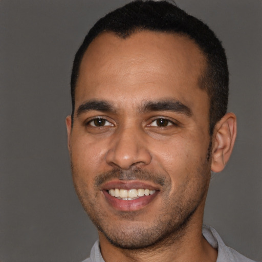 Joyful black young-adult male with short  black hair and brown eyes