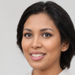 Joyful latino young-adult female with medium  brown hair and brown eyes