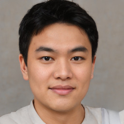 Joyful asian young-adult male with short  black hair and brown eyes