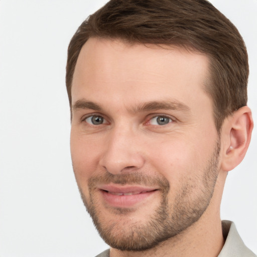 Joyful white young-adult male with short  brown hair and grey eyes