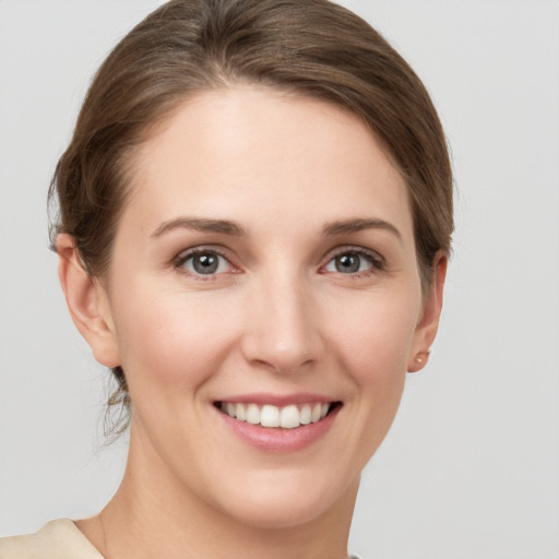 Joyful white young-adult female with medium  brown hair and grey eyes