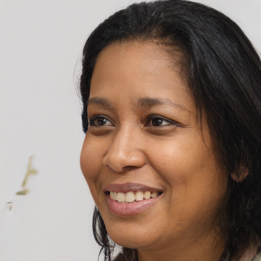 Joyful black young-adult female with long  brown hair and brown eyes