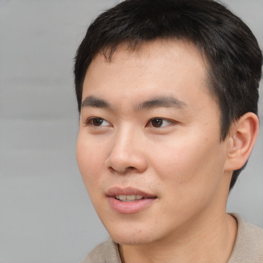 Joyful asian young-adult male with short  brown hair and brown eyes