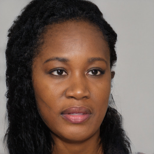 Joyful black young-adult female with long  black hair and brown eyes