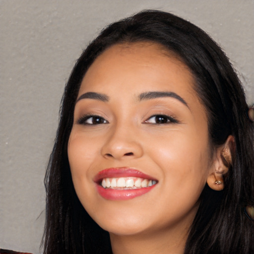 Joyful latino young-adult female with long  black hair and brown eyes