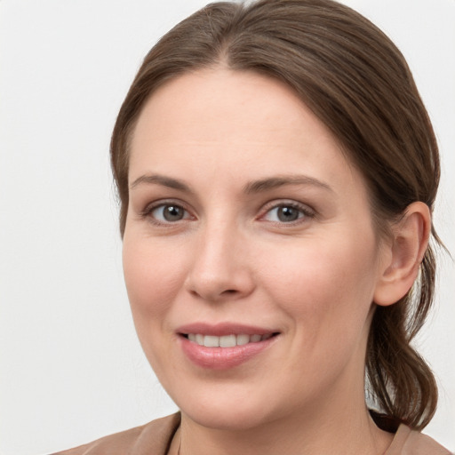 Joyful white young-adult female with medium  brown hair and grey eyes