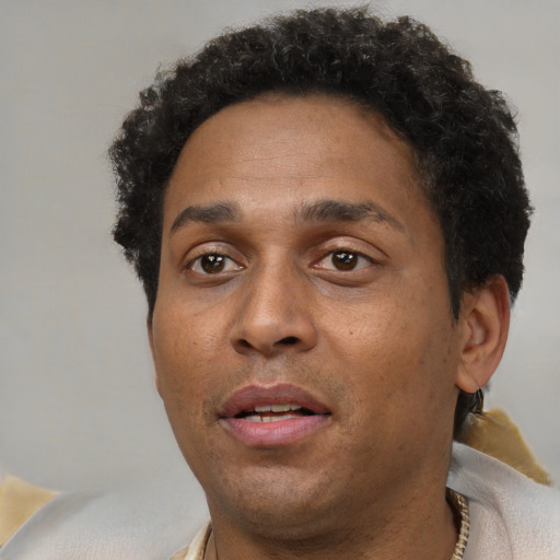 Joyful black adult male with short  brown hair and brown eyes