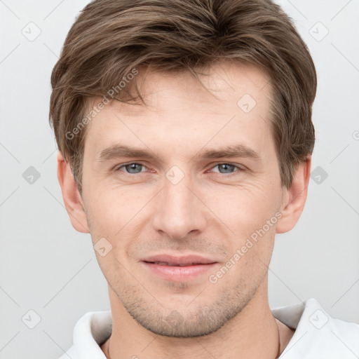 Joyful white young-adult male with short  brown hair and grey eyes