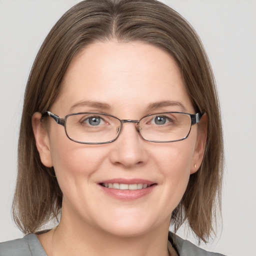 Joyful white adult female with medium  brown hair and grey eyes