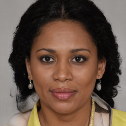 Joyful black adult female with long  brown hair and brown eyes