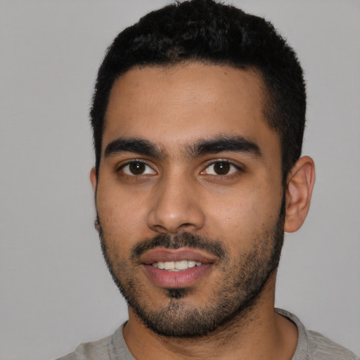 Joyful latino young-adult male with short  black hair and brown eyes