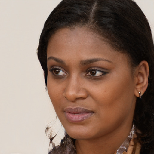 Joyful black young-adult female with long  brown hair and brown eyes