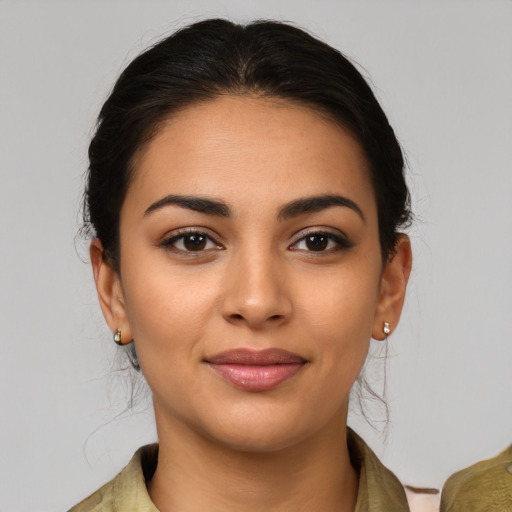 Joyful latino young-adult female with medium  brown hair and brown eyes