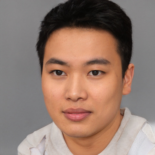 Joyful asian young-adult male with short  brown hair and brown eyes