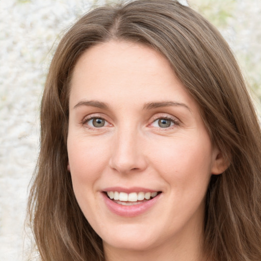 Joyful white young-adult female with long  brown hair and green eyes