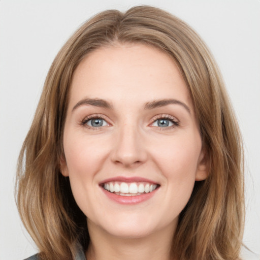 Joyful white young-adult female with medium  brown hair and green eyes