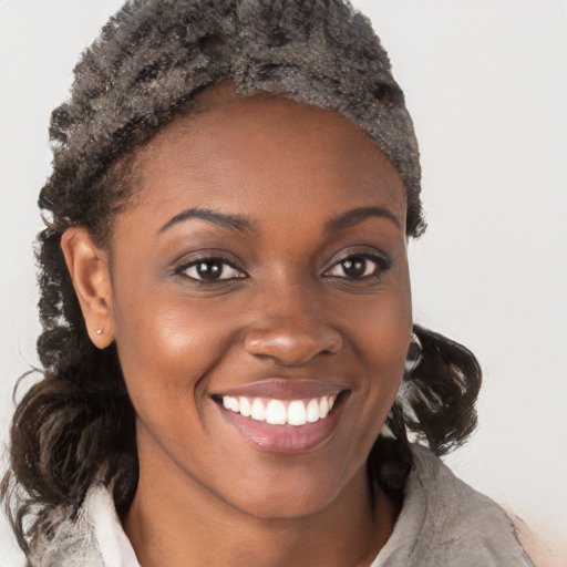 Joyful black young-adult female with short  brown hair and brown eyes