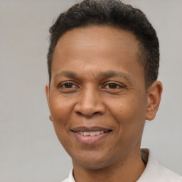 Joyful latino adult male with short  brown hair and brown eyes